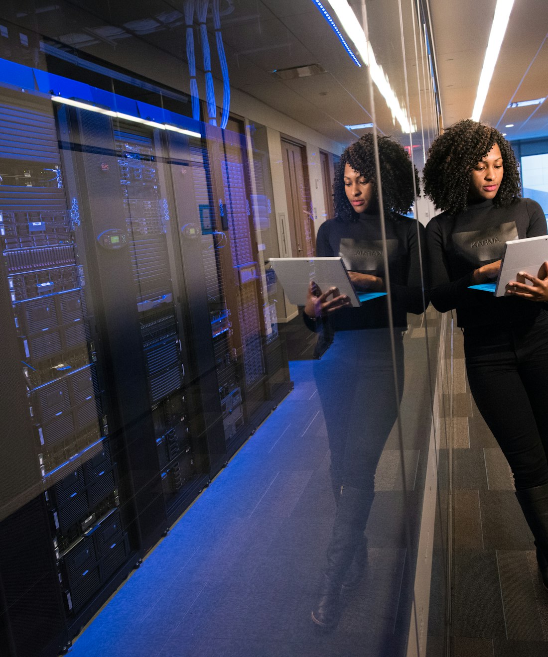 Engineer walking a data-centre corridor with a laptop